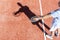 High angle view of mature man serving tennis ball on red court