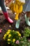 High angle view of mother and daughter watering yellow flowers