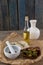 High angle view of olives with oil bottle and bread by spices in mortar pestle on table