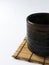 High angle view of organic Cassia herb Tea in pottery cup on the bamboo coaster isolated on a white background.