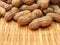 High angle view of a pile of raw peanuts also called groundnut isolated on bamboo background. Food concept.