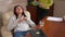 High angle view portrait of teen Asian girl in headphones sitting with closed eyes in comfortable chair with