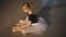 High angle view of smiling happy ballet student sitting on floor admiring new pointe shoes. Wide shot portrait of pretty
