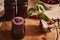 High angle view of spilled poured freshly made cherry jam in sterilized glass jars and ladle on wooden board, on kitchen