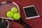 High angle view of sports shoes and digital tablet by balls on tennis racket