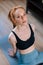 High-angle view of sporty redhead young woman wearing sportswear sitting in floor on yoga mat.