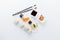 High angle view of sushi rolls and nigiri meal set with chopsticks, soy sauce, wasabi and gari on table