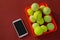 High angle view of tennis balls in red basket by mobile phone