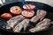 High angle view of two succulent steaks cooking on a barbecue over the hot coals on a green lawn outdoors