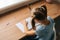 High-angle view of unrecognizable little child girl learning writing doing homework sitting at home table by window.