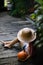 High angle view of unrecognizable little girl in hat sitting and holding organic pumpkin outdoors at farm.