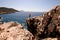 high angle view on woman standing on high rocky cliff against backdrop of seascape