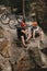 high angle view of young trial bikers relaxing on rocky cliff after ride and shaking