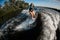 High angle view of young woman wakesurfing down the river waves