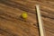 High angle of a yellow grape and a pair of chopsticks placed on a wooden table.