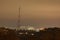 High antenna on top of the hill. Residential buildings of the Obolon district at background Evening city panorama. Kyiv, Ukraine