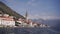 High bell tower among old houses with red roofs on the coast of the sea. Montenegro