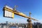 High building construction site. Big industrial tower crane with blue sky amd cityscape on background. Concrete plates weight bala