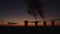 High chimneys against the backdrop of the sunset and the city. Thick smoke rises high. Silhouette of five cooling towers