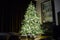 High Christmas tree with ornaments and garlands