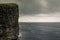 High cliff, viewpoint to the Drangarnir rock formation and Tindholmur islet, A person standing at the top of the cliff works as