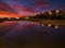 High cloud sunrise at the seaside with street lights and reflections