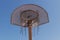 High contrast frontal image of metal basketball hoop backlit with sun flare, black and white