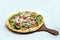 `A high contrast Hero shot of a Bruschetta Al Pesto Spinaci Pizza, on a minimal white background with a 60 degree angle from zoome