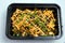 A high contrast Hero shot of a Take-Away Hot Loaded fries / chips with cheese, ground meat, olives, jalapeno, sauce & oregano, on