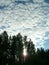 High cumulus and Cirrocumulus clouds. Sunset. Picturesque landscape of forest, sky and clouds. Karelia, Russia. The sun breaks