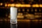 High elegant glass filled with ice cubes on the bar counter of restaurant in blurred background