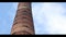 High factory chimney red brick in the background passing in the sky clouds