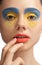 High fashion look, closeup beauty portrait,bright makeup with perfect clean skin with colorful red lips and blue yellow