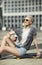 High fashion look. glamour joyful beautiful young blond girl in summer bright casual hipster clothes sitting on a little