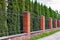 High fence with brick columns. Black Railings and brick wall