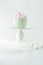 High food tray with mint green ceramic bowl filled with pink and white heartshaped marshmallows on white fur and light grey underg