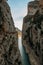 A high gorge of rocks and a mountain river. Deep narrow canyon along the river.