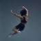 High jump. Relief back, Dynamic image of young beautiful woman in sportswear training, posing in motion against grey