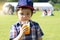 High key Portrait of kid boy drinking orange slush from plastic glass in hot sunny day,Thirsty child drinking frozen orange slush