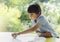 High key portrait of school kid playing game in playroomwith blurry natural background, Child holding bottom game with wondering