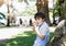 High key protrait Happy boy eatting chocolate cake siting in the park, Kid looking at camera with smiling face whie eating walnut