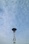 A high lamppost under a bright cloud