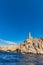 High lighthouse on the edge of high cliff seen from boat