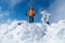 High mountaineer dressed bright orange softshell jacket on the snowy mountain summit.  Active people concept image on Velky