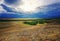 The high-mountainous steppe Chuiskaya in the rays of the sun because of the clouds of a group of trees stony land