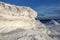 High mountains and blue sky. Mysterious fantastic rocks frozen with ice and snow of strange fairytales forms and structures.