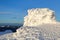 High mountains and blue sky. Mysterious fantastic rocks frozen with ice and snow of strange fairytales forms and structures.