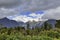 High mountains with snow on top in the winter, beautiful skies and clouds. The grass is yellow in Mount Cook Rd