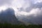 High mountans and valley with forest in fog and clouds