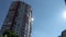 High multi-storey residental building, sunlight in a window. View from a street